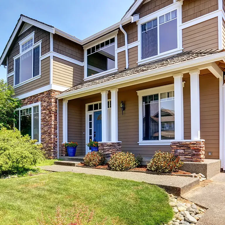 A two-story home with mirror film on its windows, similar to 3M’s night vision series of residential window tinting.