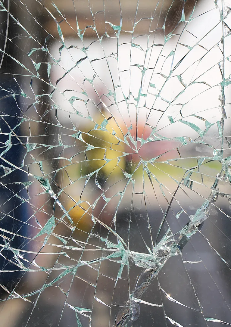 Looking outside through shattered glass held in place by 3m safety and security films.