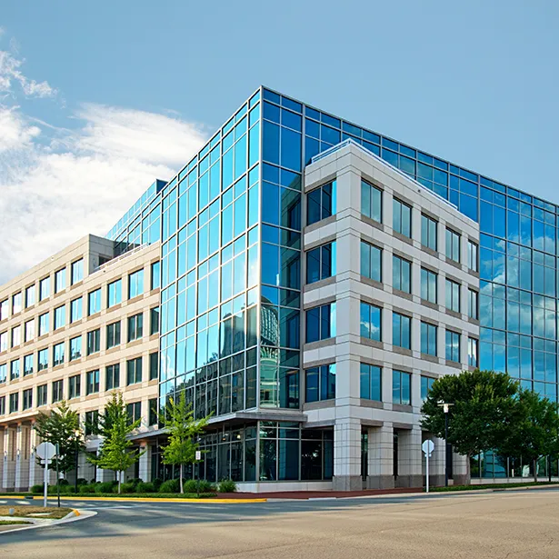 A multi-story commercial facility has mirror film across its glass providing a look similar to that you can achieve with 3M prestige series sun control building window tinting.