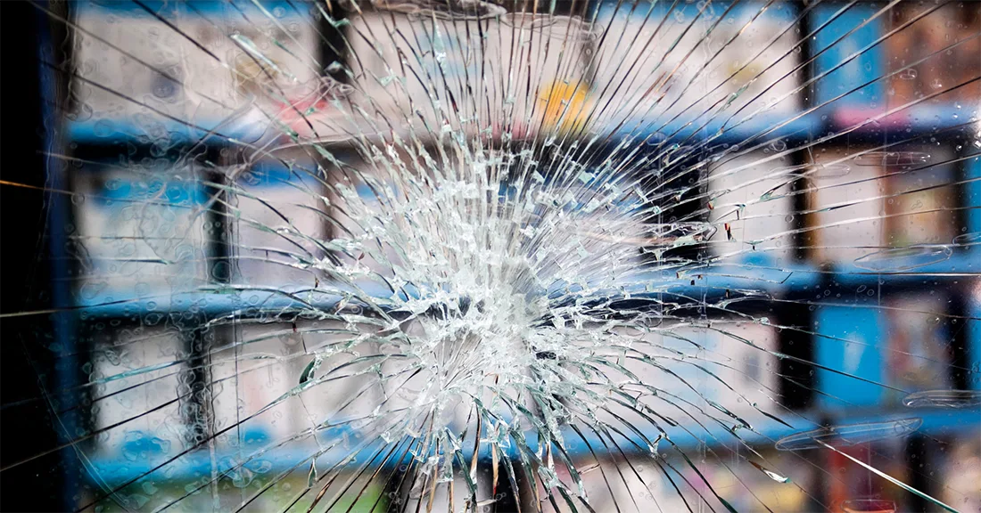 Shattered glass is held together outside of a retail store by safety and security film.