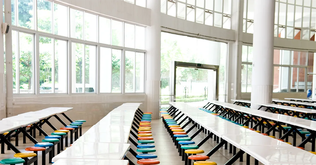 An elementary school cafeteria with large bay windows that can be protected by school safety film