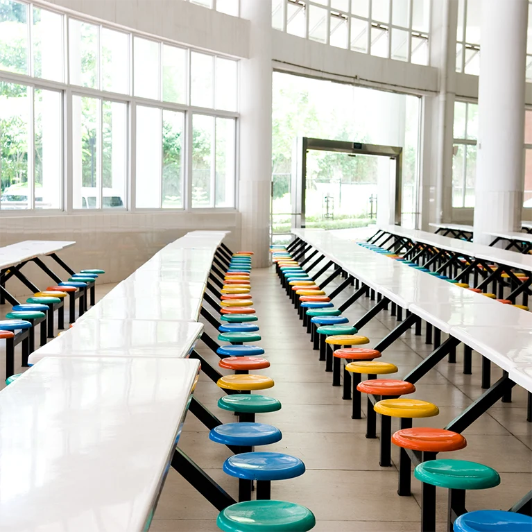 Large windows in a school cafeteria cast natural sunlight into the room and can be protected by 3M window film.
